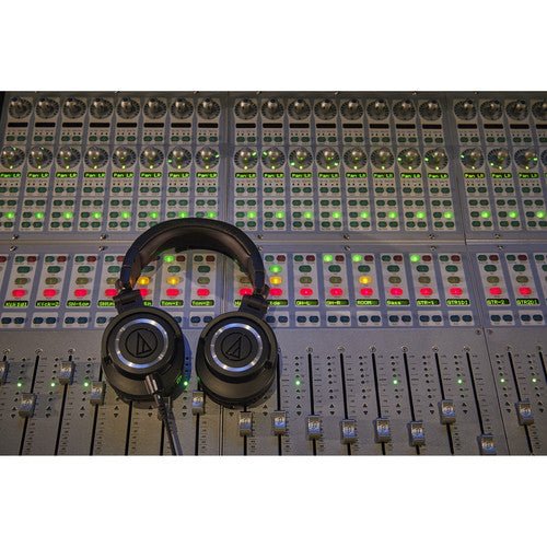 Audio-Technica ATH-M50x Kenya resting on a professional mixing console in a recording studio environment