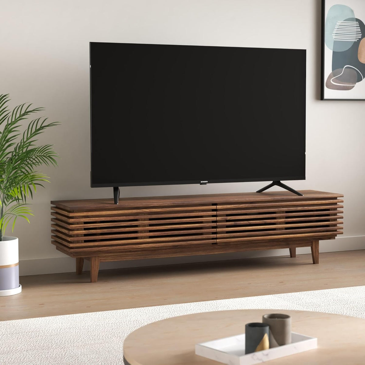 Skyworth 55 QLED TV Kenya in living room setup on wooden TV unit with plant and wall art in background
