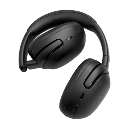 Black JBL Tour One M3 over-ear headphones resting on their folding hinge, earcups showing plush memory-foam cushions.