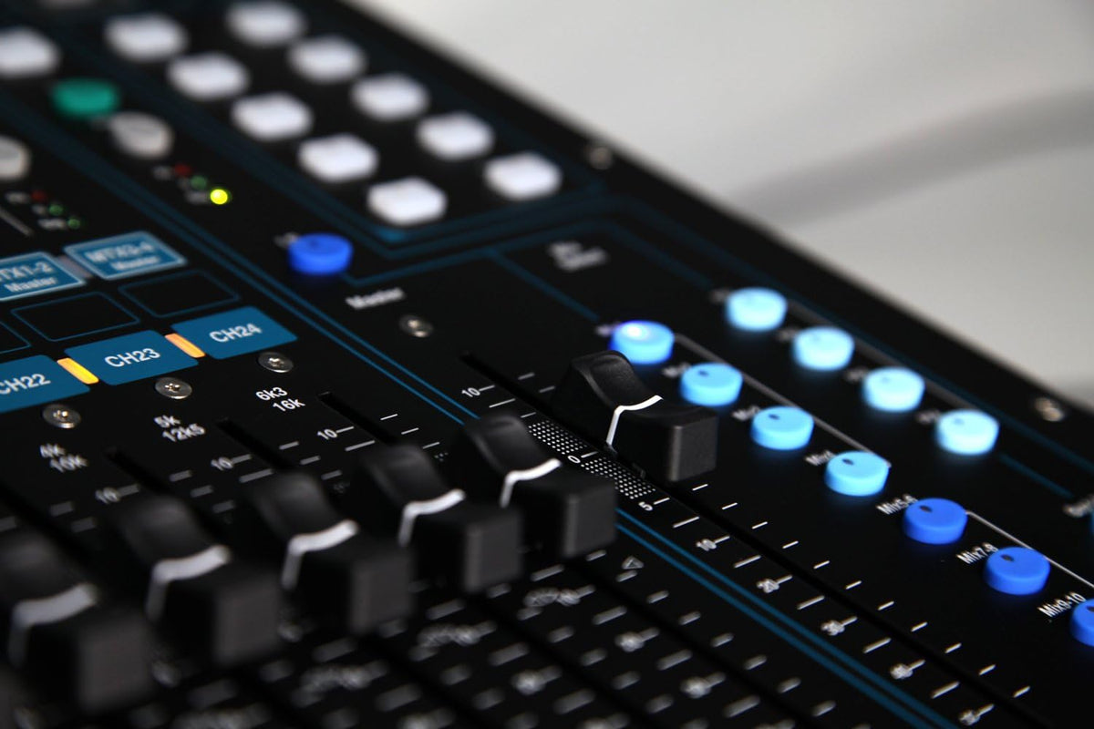 Allen Heath Qu-24 Kenya close-up of CH22-24 faders and blue-illuminated mix select buttons on right panel`