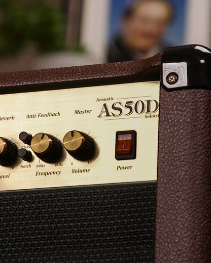 Close-up of an Acoustic AS50D amplifier with control knobs and branding.