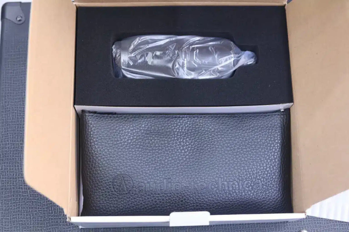 Audio-Technica AT2020 Kenya unboxing shot showing mic wrapped in plastic and protective pouch inside open retail box