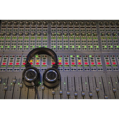 Audio-Technica ATH-M50x Kenya resting on a professional mixing console in a recording studio environment