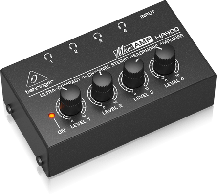 Behringer HA400 headphone amplifier Kenya lifestyle shot — man wearing earphones beside unit showing ultra-compact 4-channel design