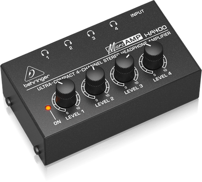 Behringer HA400 headphone amplifier Kenya lifestyle shot — man wearing earphones beside unit showing ultra-compact 4-channel design