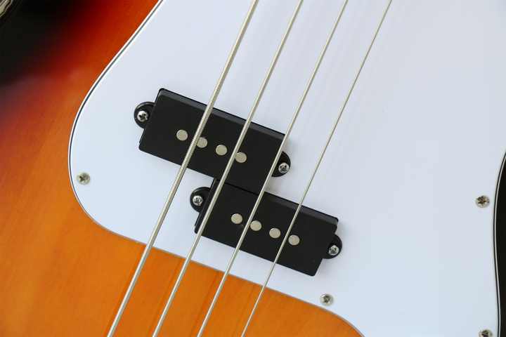 Fender Precision Bass Kenya split single-coil pickup macro on sunburst body with white scratchplate