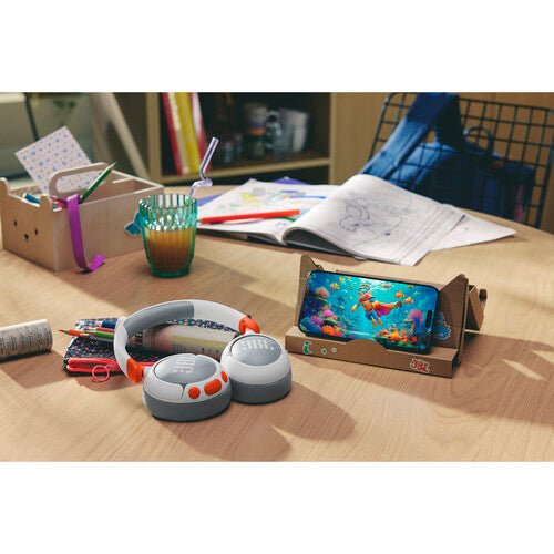 JBL Junior 470NC headphones Kenya beside a tablet and school supplies on a desk