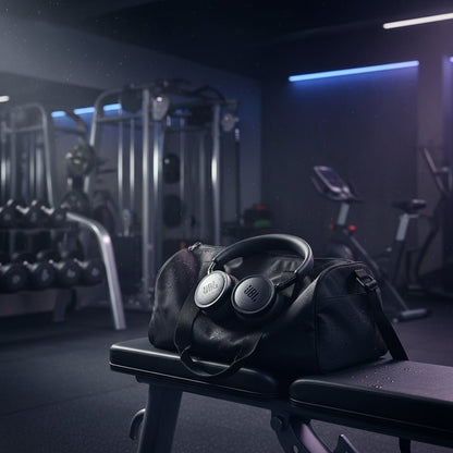 JBL Live 680NC Kenya headphones resting on a gym bag in a dark fitness studio