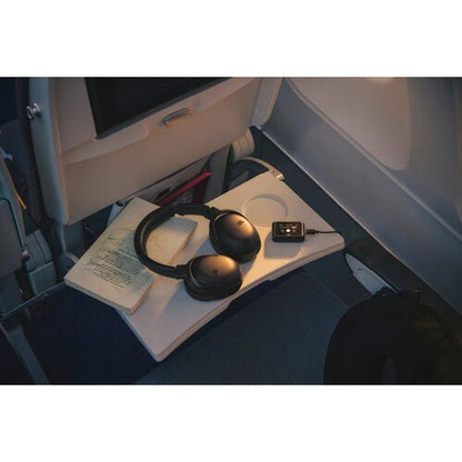 JBL Tour One M3 Smart TX Kenya headphones and transmitter on an airplane seat beside a book