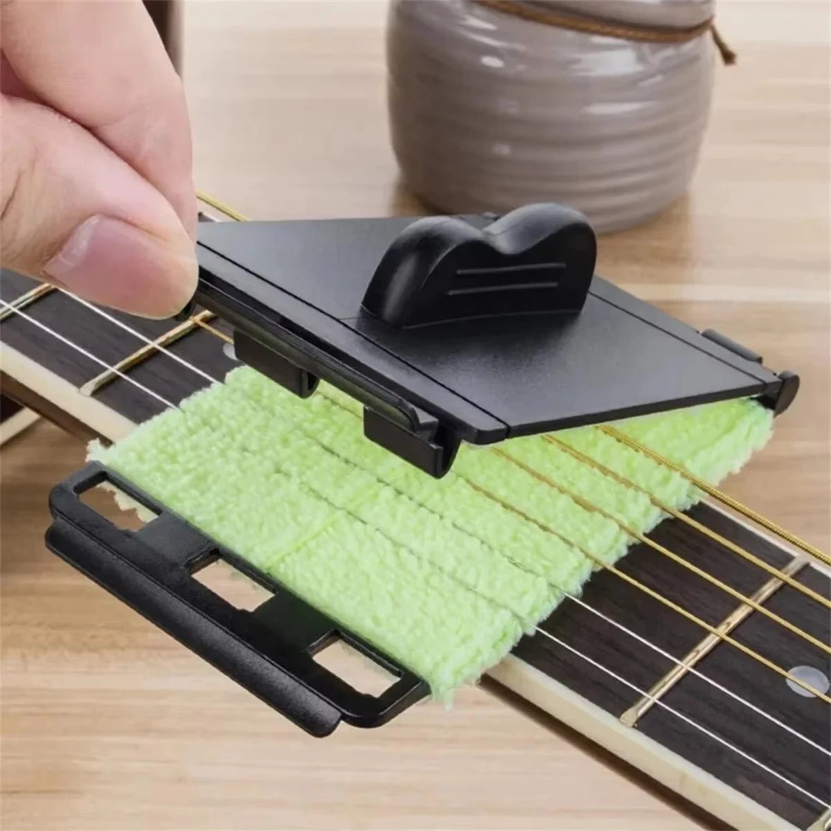 Miwayer guitar string cleaner wrapping around guitar strings to remove sweat and grime