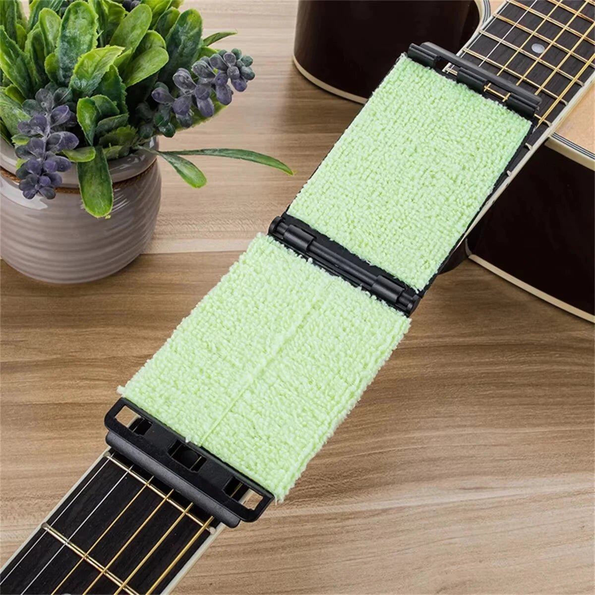 Miwayer guitar string cleaner wrapping around guitar strings to remove sweat and grime