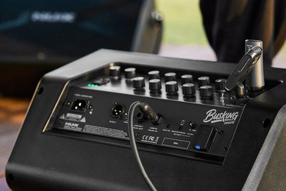 NUX Busking 200FR PA Kenya in outdoor use with XLR cable connected, green LEDs and wireless mic on top
