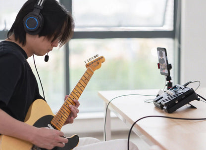 NUX MG-101 guitar processor Kenya — guitarist using MG-101 with headphones for silent practice and mobile recording