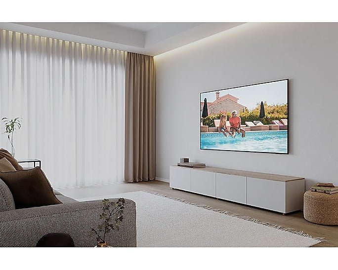 Samsung 75DU8000 Kenya wall-mounted in a bright modern living room displaying a poolside lifestyle scene