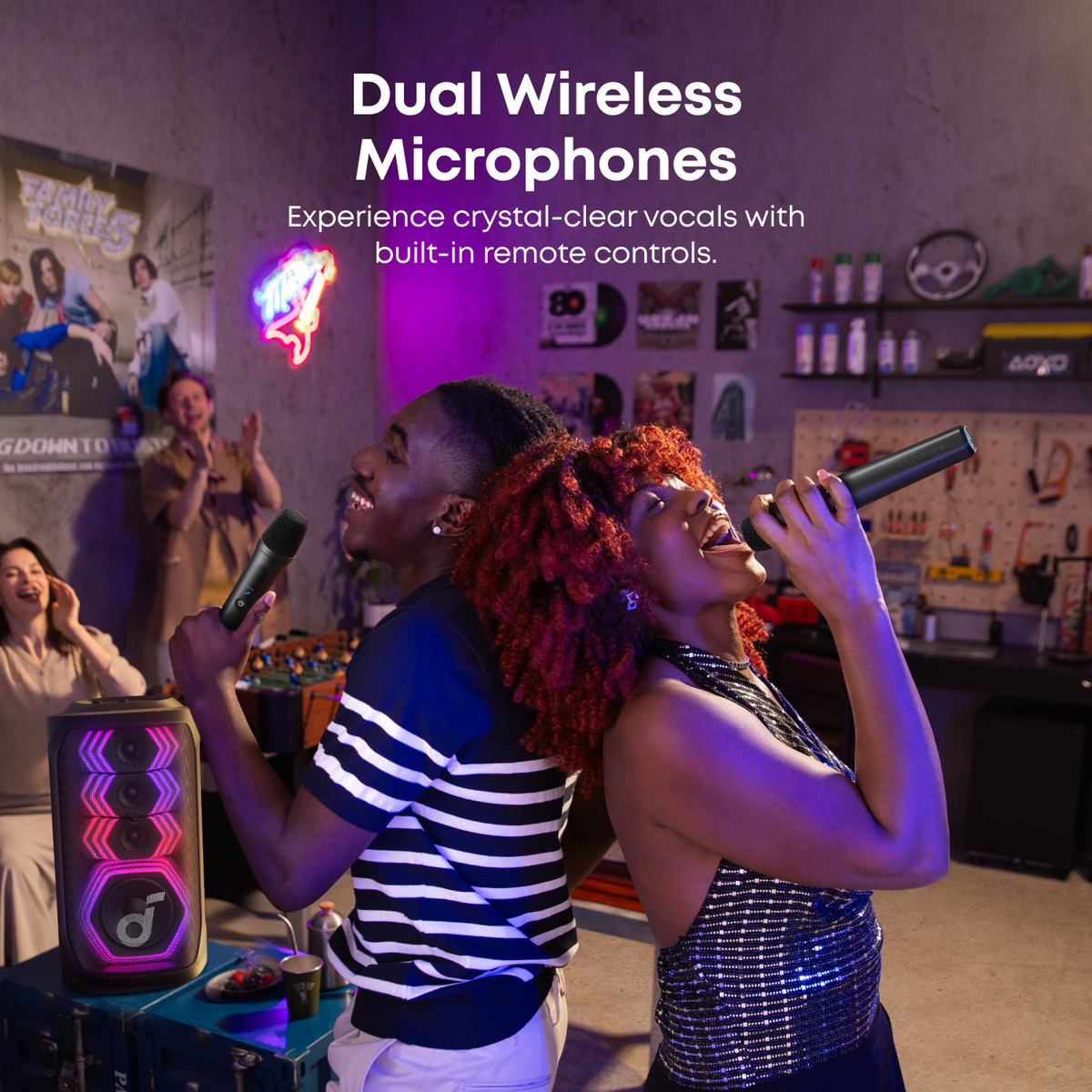 Two women singing with wireless mics at indoor party with Soundcore Rave 3S karaoke speaker Kenya glowing in background