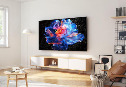 TCL 55V6C Google TV Kenya wall-mounted in a modern living room above a wooden TV unit with ambient lighting